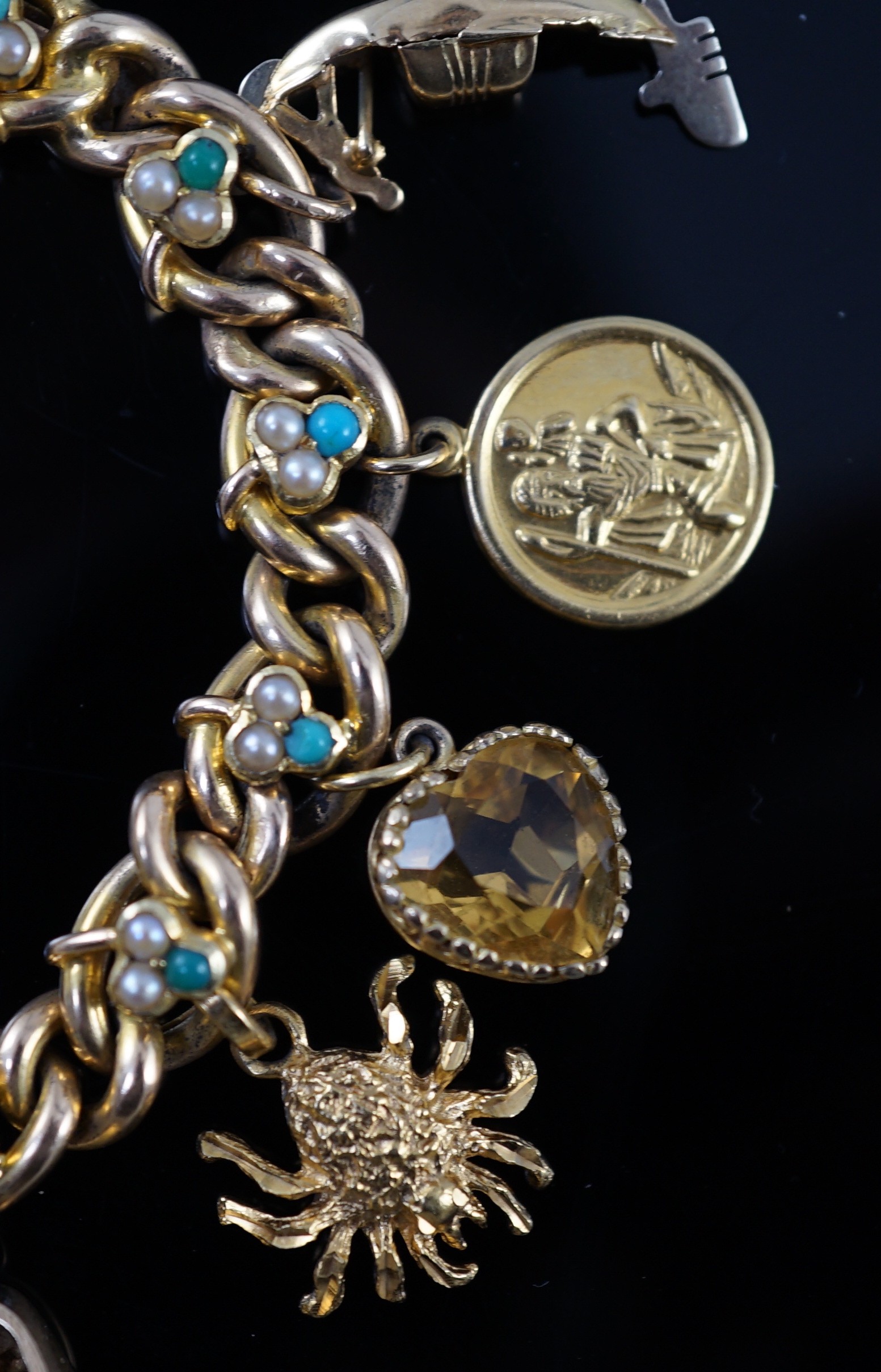 An Edwardian 15ct gold, seed pearl and turquoise set curb link charm bracelet